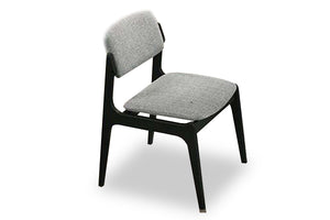 Silla de comedor moderna con asiento y respaldo acolchados en tela gris clara, estructura de madera negra y patas inclinadas, presentada sobre fondo blanco.