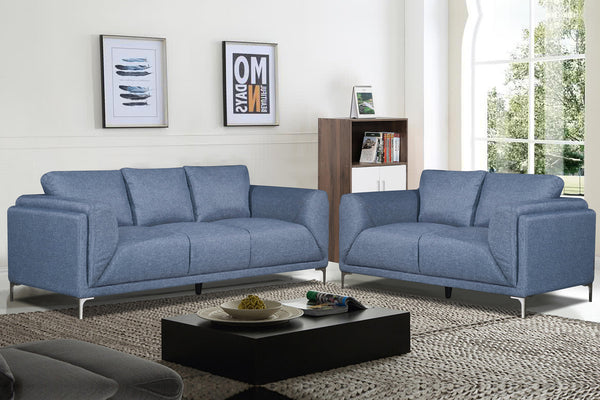 Sofá y loveseat de color azul en una sala con elementos decorativos. 