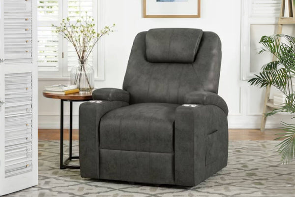 Sillón reclinable gris en una sala de estar con una mesa pequeña y plantas.