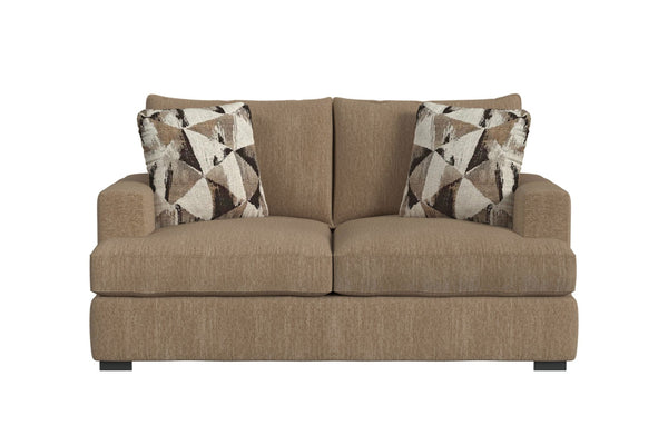 Loveseat de color marrón con dos cojines decorativos sobre un fondo blanco. 