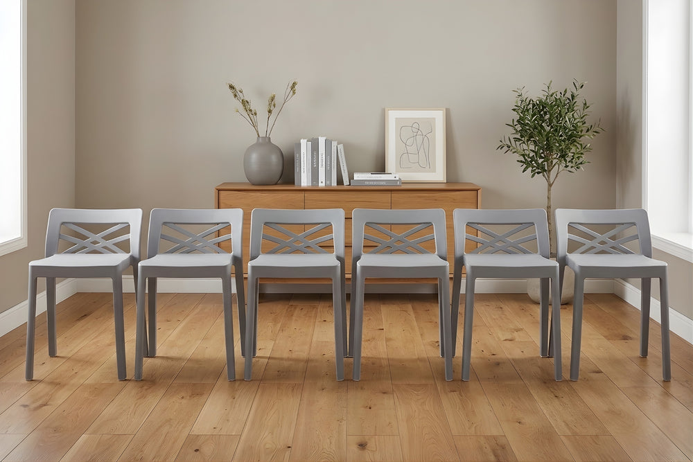 Conjunto de seis sillas grises dispuestas en fila sobre un suelo de madera, con una pared de color neutro al fondo.