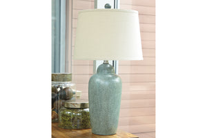 Lámpara de mesa con base verde texturizada y pantalla blanca sobre superficie de madera.