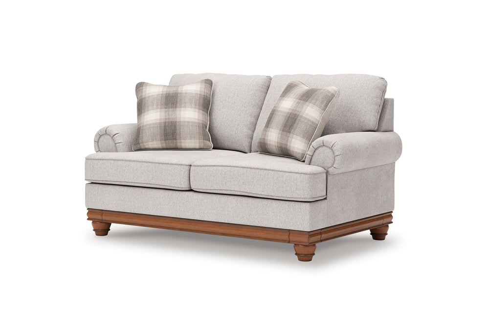 Loveseat gris claro con patas de madera y cojines a cuadros sobre fondo blanco.