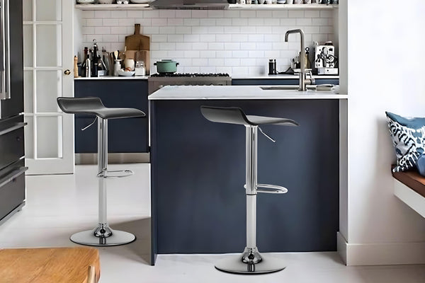 Dos taburetes de color negro en un fondo de cocina con elementos decorativos. 