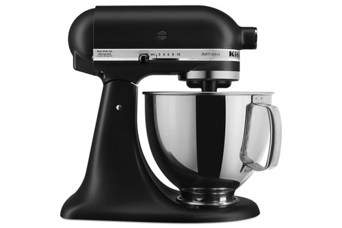 Una batidora de pie KitchenAid Artisan en color negro mate con un recipiente de acero inoxidable y un pico vertedor de plástico transparente, mostrada sobre un fondo blanco liso.