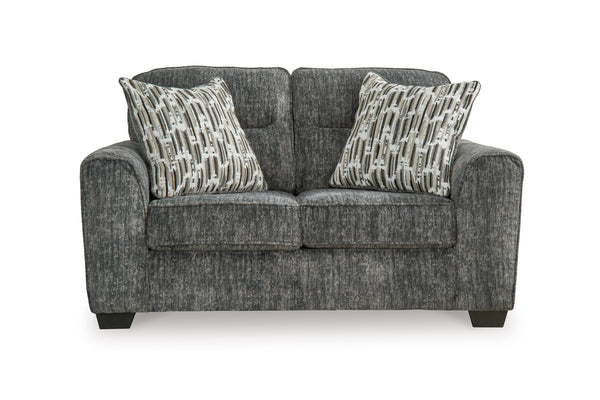 Loveseat de color gris oscuro con cojines decorativos sobre un fondo blanco. 
