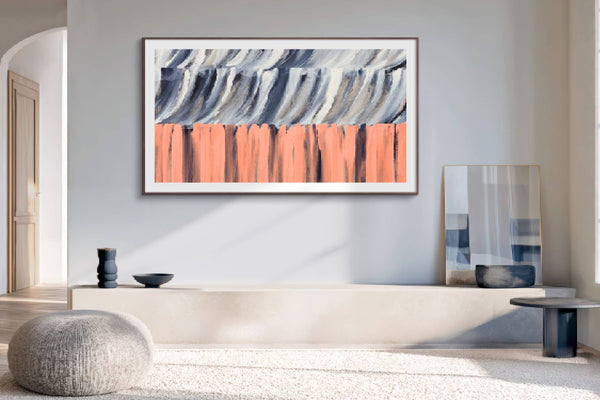 Vista cercana de sala de estar moderna con un televisor de pantalla plana montado en la pared que muestra una obra de arte abstracta en tonos gris, blanco, negro y coral. El espacio incluye muebles minimalistas, luz natural y decoración contemporánea.