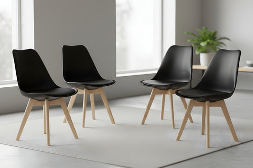 Cuatro sillas negras con patas de madera dispuestas en una habitación moderna.