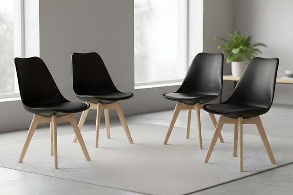 Cuatro sillas negras con patas de madera dispuestas en una habitación moderna.