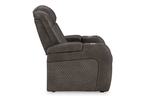 Vista lateral de butaca reclinable eléctrica de color marrón sobre un fondo blanco. 