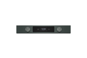 Un dispositivo electrónico elegante y minimalista con un cuerpo rectangular de color verde, que cuenta con dos perillas plateadas metálicas y una pantalla central negra que muestra la hora 12:03.