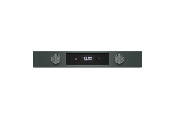 Un dispositivo electrónico elegante y minimalista con un cuerpo rectangular de color verde, que cuenta con dos perillas plateadas metálicas y una pantalla central negra que muestra la hora 12:03.