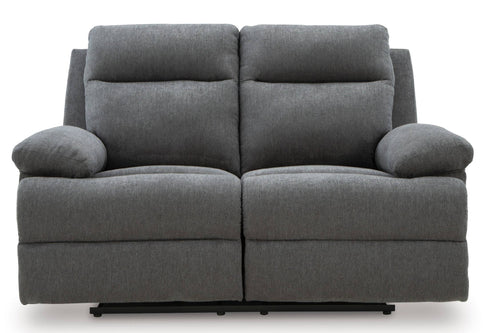 Un sofá reclinable de dos plazas en tela gris con dos cojines de asiento independientes y reposabrazos acolchados, mostrado sobre un fondo blanco liso.