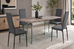 Una escena de comedor moderno que muestra una mesa rectangular de madera con patas de cristal transparente y cuatro sillas de comedor tapizadas en gris.