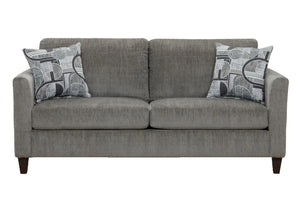Sofá moderno tapizado en tela gris con cojines de asiento amplios, apoyabrazos rectos y dos cojines decorativos con diseño geométrico en tonos gris y blanco, presentado sobre fondo blanco.