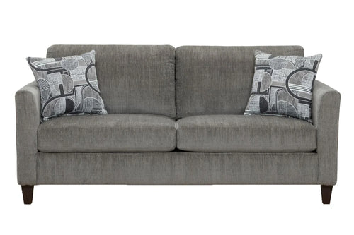 Sofá moderno tapizado en tela gris con cojines de asiento amplios, apoyabrazos rectos y dos cojines decorativos con diseño geométrico en tonos gris y blanco, presentado sobre fondo blanco.