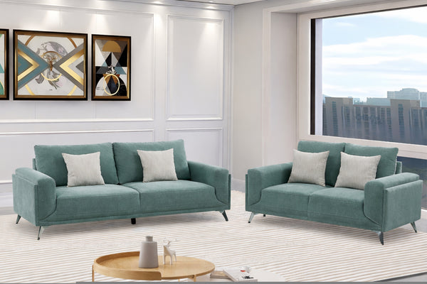 Conjunto de sofás y loveseat verde en una sala de estar moderna con vista al paisaje urbano