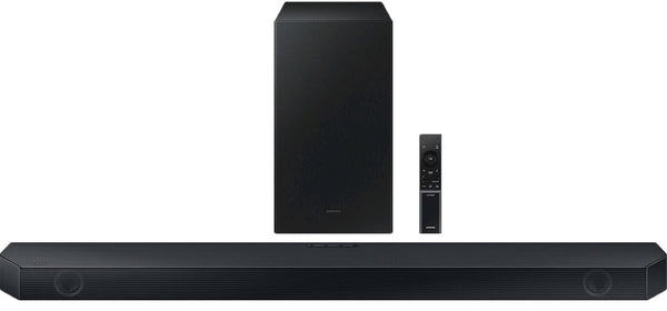 Barra de sonido negra con subwoofer y control remoto sobre fondo blanco. 