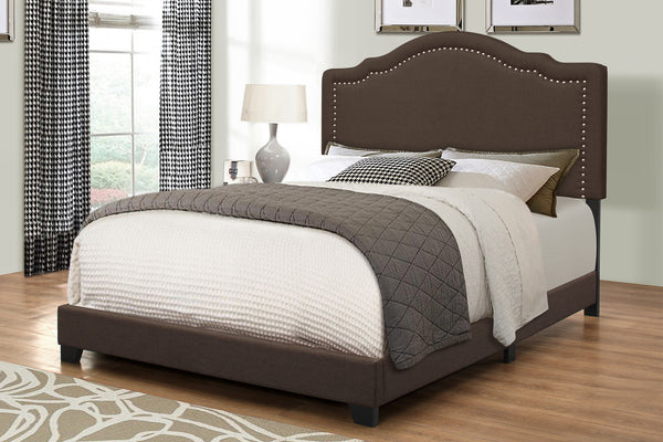 Cama tapizada en marrón con acolchado blanco y gris en una habitación neutral. 