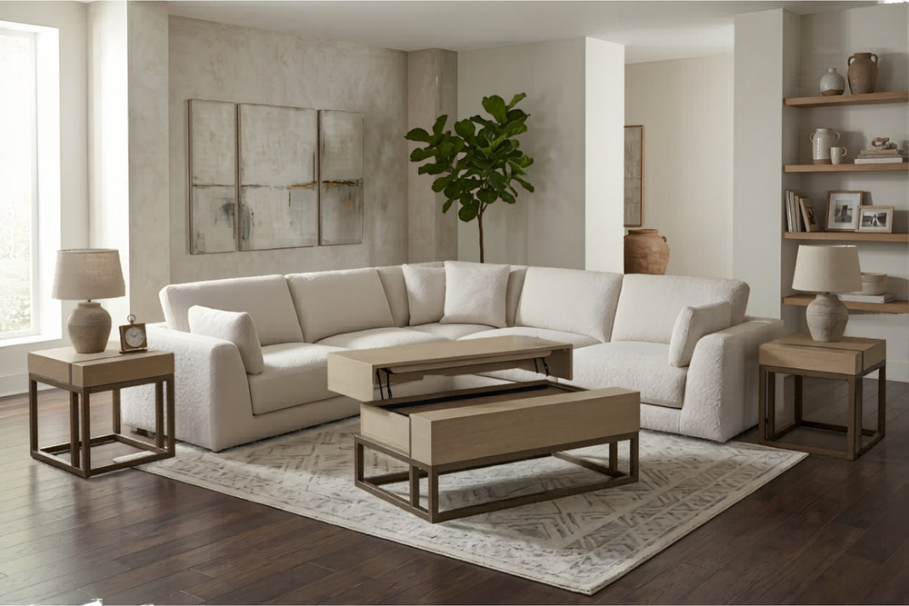 Sofá seccional en forma de L tapizado en tela color crema, con amplios cojines de asiento y respaldo, brazos rectos y cojines decorativos a ambos lados.