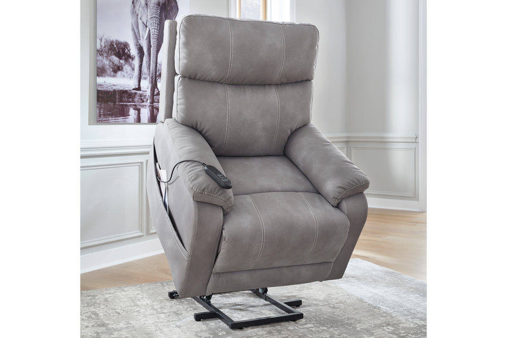 Butaca reclinable eléctrica tipo lift color beige, tapizada de apariencia piel, con respaldo alto acolchado, brazos anchos, reposapiés integrado y base metálica elevadora sobre un fondo blanco.
