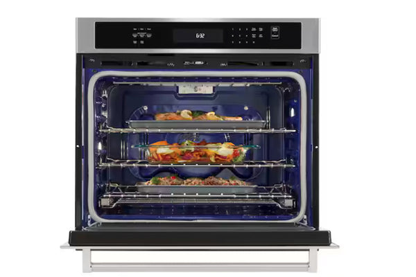 Horno empotrable KitchenAid en acero inoxidable con puerta abierta, interior azul esmaltado y tres niveles de cocción. Muestra bandejas con alimentos en diferentes parrillas para una cocción uniforme y mayor capacidad de horneado.