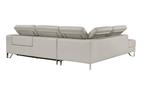 Sofá seccional moderno de color gris claro con chaise longue orientada hacia la izquierda y cojines de respaldo elevados, mostrado desde un ángulo de tres cuartos sobre un fondo blanco.
