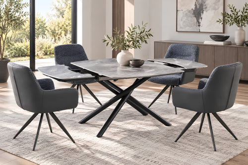 Juego de comedor moderno con mesa rectangular gris apariencia piedra y base metálica en X, con cuatro sillas tapizadas en gris en un comedor luminoso.