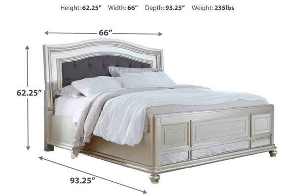 Cama tapizada y plateada con dimensiones marcados en negro sobre un fondo blanco. 