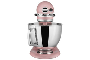 Una batidora de pie KitchenAid clásica de color rosa con un bol de acero inoxidable, mostrada sobre un fondo blanco liso.