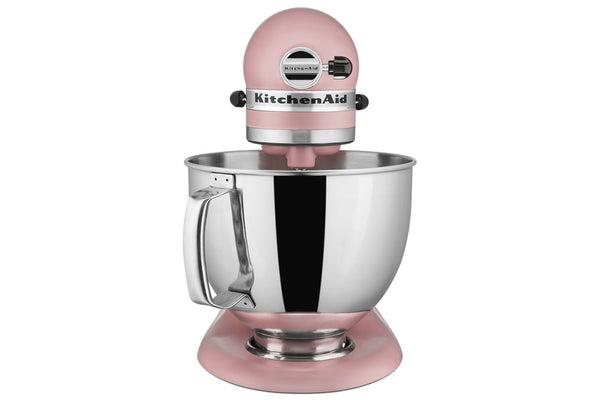 Una batidora de pie KitchenAid clásica de color rosa con un bol de acero inoxidable, mostrada sobre un fondo blanco liso.