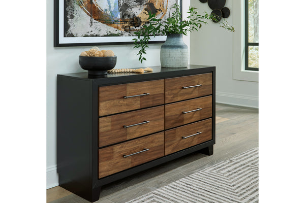 Gavetero con gavetas de madera y tapa negra en ambiente de habitación.