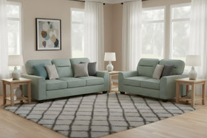 Sofá y loveseat de color verde menta en una sala moderna con ventanas y elementos decorativos. 