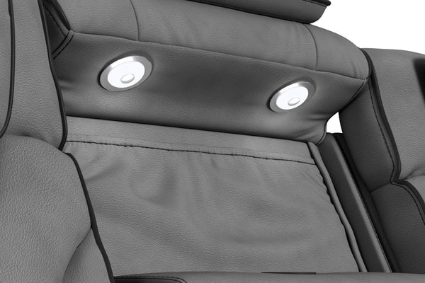 Primer plano del respaldo central de un sofá reclinable gris oscuro con dos luces LED de lectura integradas. Tapizado acolchado de textura suave y diseño ergonómico orientado al confort y entretenimiento en el hogar.