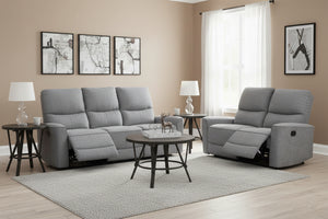 Conjunto de sofá reclinable gris en sala de estar con mesas de esquina, una mesa de centro redonda y con lámparas.