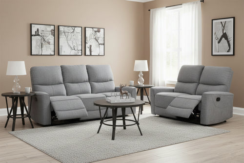 Conjunto de sofá reclinable gris en sala de estar con mesas de esquina, una mesa de centro redonda y con lámparas.