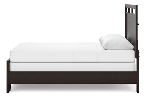 Cama de madera oscura con ropa de cama blanca sobre fondo blanco.