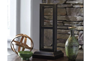 Lámpara decorativa con pared de piedra y elementos decorativos al fondo.