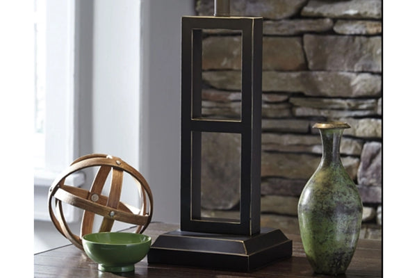 Lámpara decorativa con pared de piedra y elementos decorativos al fondo.