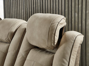Sillón reclinable beige con reposacabezas sobre un fondo neutro.