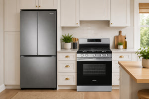 Una nevera de acero inoxidable con puertas francesas se sitúa a la izquierda de una cocina de gas y un horno a juego en una cocina luminosa y moderna con armarios blancos y detalles de madera.