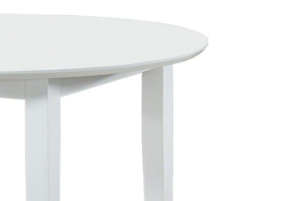 Vista cercana de esquina de mesa redonda y blanca sobre un fondo blanco. 