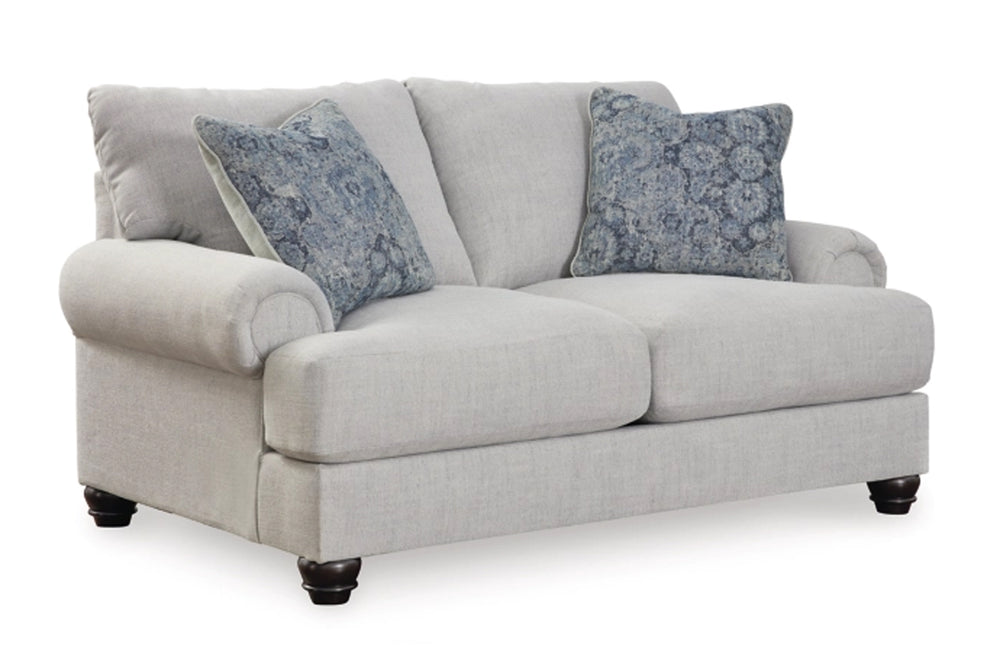 Loveseat de color gris claro con cojines sobre un fondo blanco. 