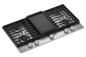 Un tope de cocción de gas de 91 cm (36 pulgadas) con una plancha negra de superficie plana, cuatro quemadores con rejillas negras y un panel frontal de acero inoxidable con cinco perillas de control.