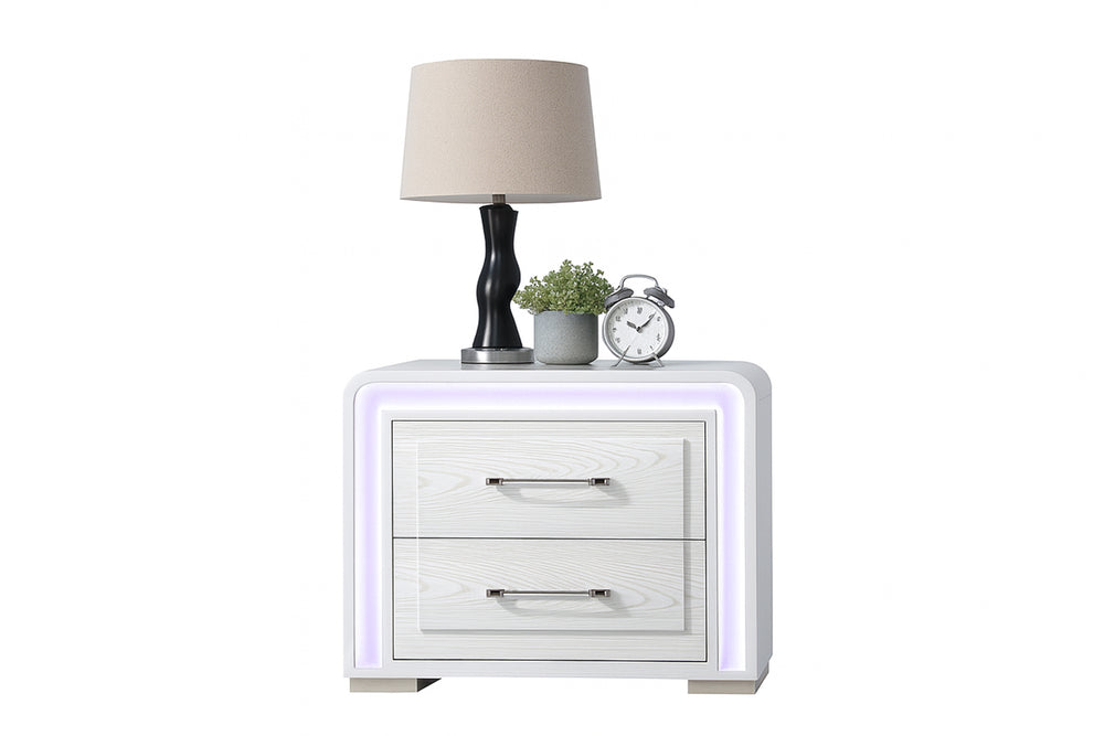 Mesa de noche de color blanco con dos gavetas, luces LED, y elementos decorativos encima de la mesa sobre un fondo blanco. 