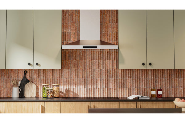 Un interior de cocina moderno que presenta un llamativo salpicadero de azulejos verticales acanalados de cobre o bronce detrás de una encimera oscura, con armarios de madera clara y una campana extractora a juego.