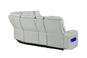 Vista posterior y lateral de sofá seccional reclinable en color gris claro con tapizado liso, respaldos altos acolchados y detalle de iluminación LED azul integrada en el brazo lateral. Diseño modular con acabados modernos y líneas limpias.