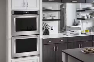 Horno doble empotrable KitchenAid en acero inoxidable instalado en una cocina moderna. Cuenta con dos cavidades independientes, puertas de vidrio negro y diseño integrado que combina con gabinetes y superficies contemporáneas