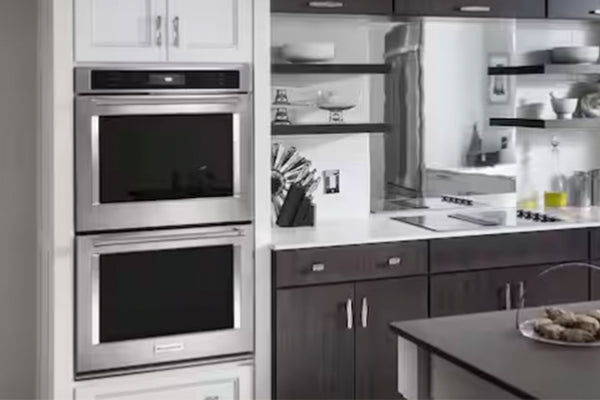 Horno doble empotrable KitchenAid en acero inoxidable instalado en una cocina moderna. Cuenta con dos cavidades independientes, puertas de vidrio negro y diseño integrado que combina con gabinetes y superficies contemporáneas