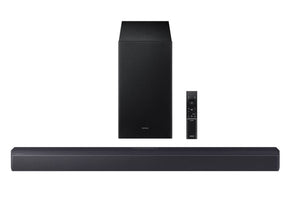 Barra de sonido negra con subwoofer y control remoto sobre fondo blanco. 